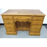 A contemporary pine knee hole desk, moulded top, a long central drawer flanked by four short drawers