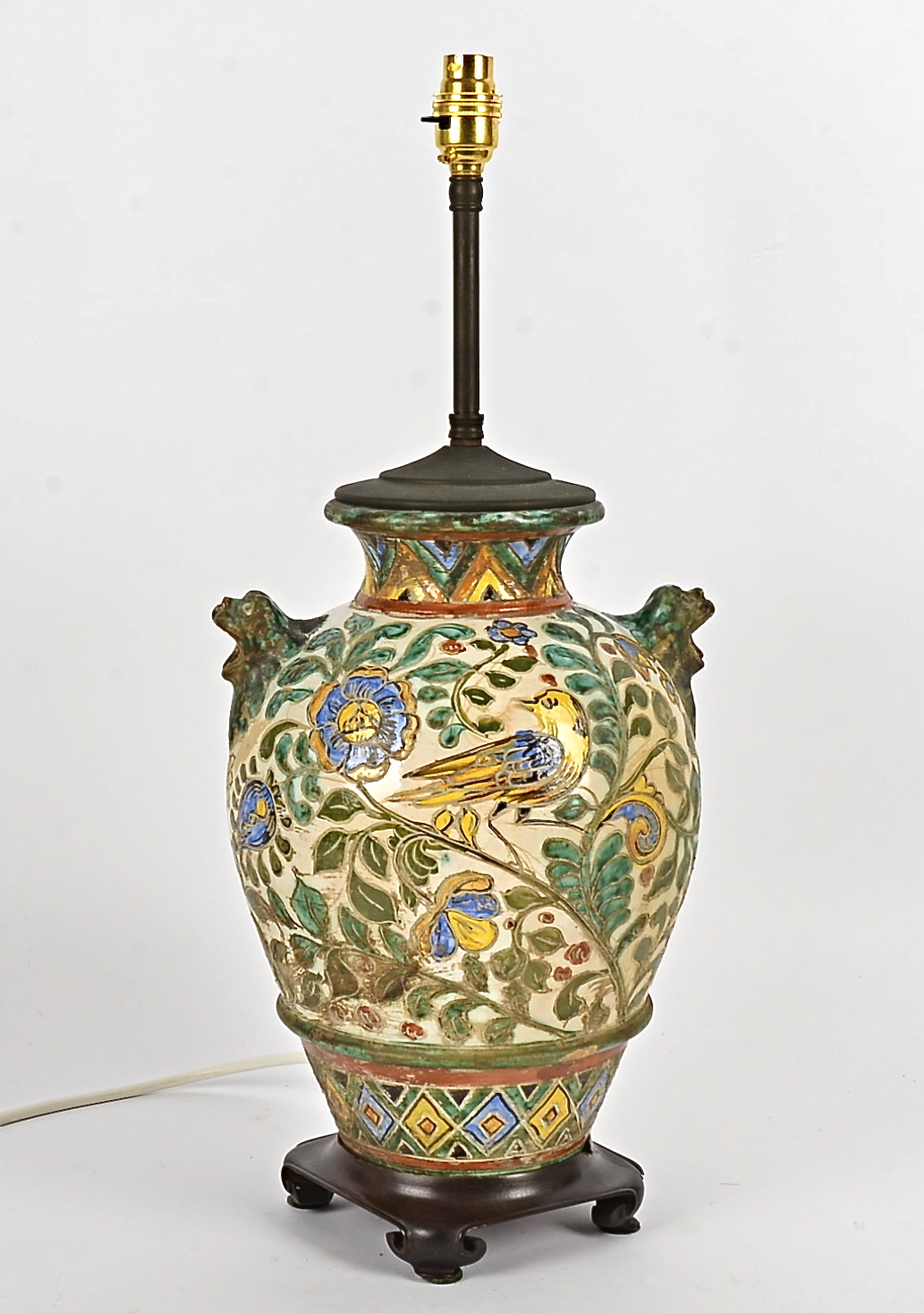 An Arts and Crafts style table lamp, decorated with birds and foliage and twin handles in the form