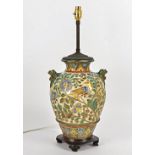 An Arts and Crafts style table lamp, decorated with birds and foliage and twin handles in the form