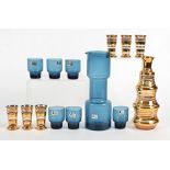 A Swedish glass liquor set, in blue with six glasses, together with a set with striped gilt