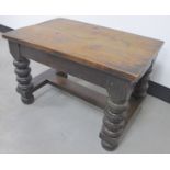 An antique elm top rectangular coffee table, with bulbous turned supports, H stretcher, raised on
