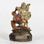 A 19th Century Chinese soapstone carved figure, modelled as a seated warrior upon a mythical