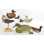 A collection of wooden models of wildfowl, some handpainted, together with a carved stone example (