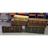 Two large early 20th Century wooden travelling trunks, one with iron binding and side handles,