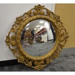 A giltwood circular convex wall mirror, with foliate design frame, diameter 85cm, together with a