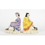 A pair of continental Art Deco pottery bookends, modelled as seated fashionable ladies, one in a