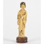 A Japanese ivory of a Geisha, raised upon a wooden base, height 13cm