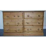 A contemporary pine chest of drawers, comprising of six short drawers, moulded top raised on a