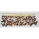 A collection of Chinese and Asian conquilla nut beads, with carved decorations of figures,
