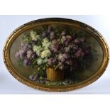 A late 19th/early 20th Century oil on canvas, still life of lilacs in a basket, signed (lower right)