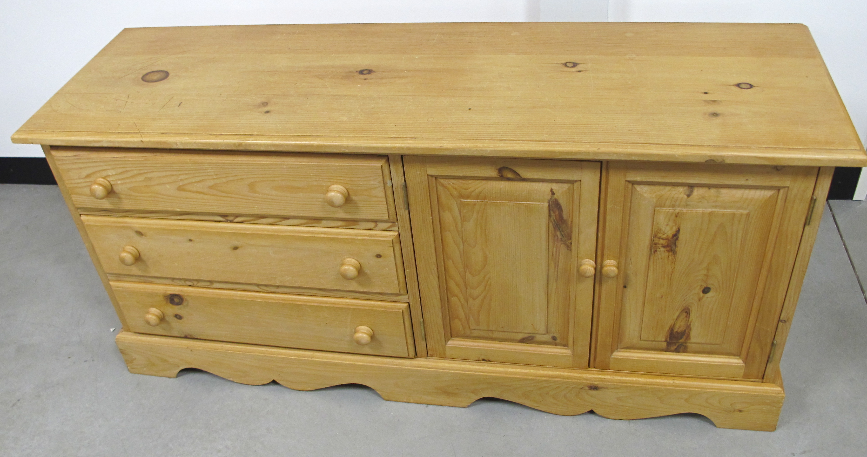 A contemporary pine cabinet, three long drawers and two panelled cuboard doors to opposite side,