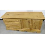 A contemporary pine cabinet, three long drawers and two panelled cuboard doors to opposite side,