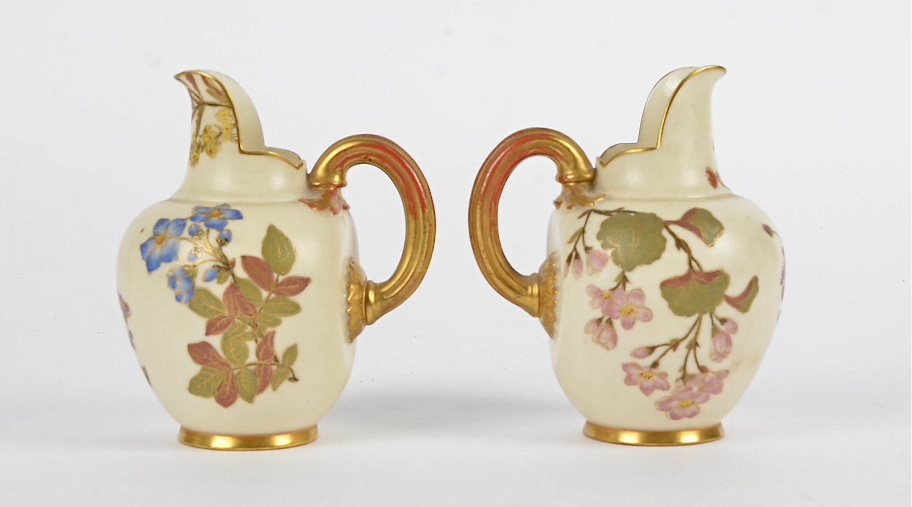 A pair of Royal Worcester flat-back jugs, each with with gold gilt and floral decoration on a