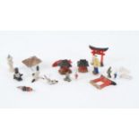 A collection of miniature Japanese porcelain figures, together with a small black baby, largest