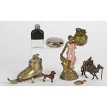 Three novelty lighters, modelled as a ski boot, a camel rider and a woman carrying a basket,