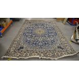 An Iranian 20th Century woollen rug, the central medallion upon blue ground, with floral decoration,