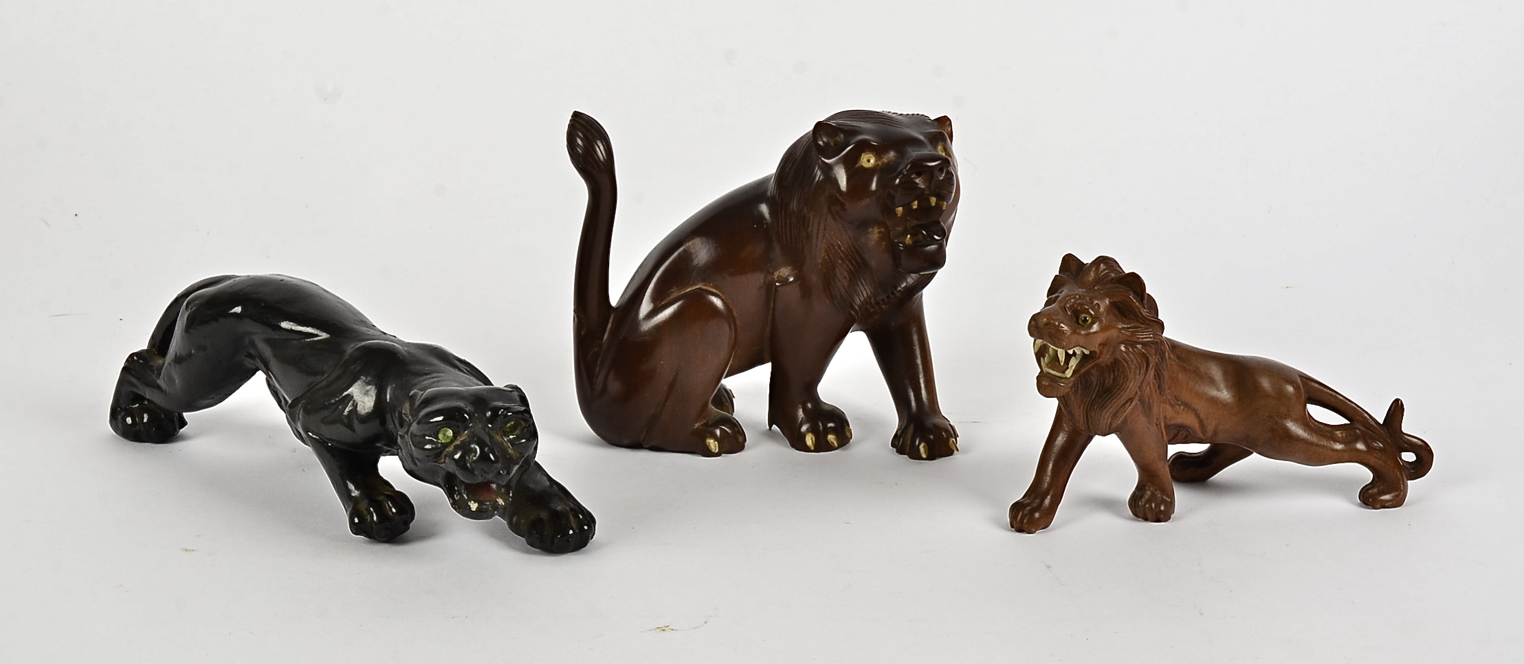 Three early 20th Century Asian boxwood and composite animal figures, two lions and one panther,