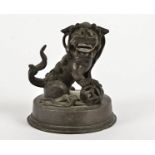A 19th Century Chinese bronze figurine, modelled as a male dog of Fo, on a circular base with