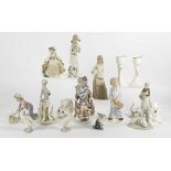 A small group of Lladro ceramics, including girls and geese, kittens and clowns and a few other