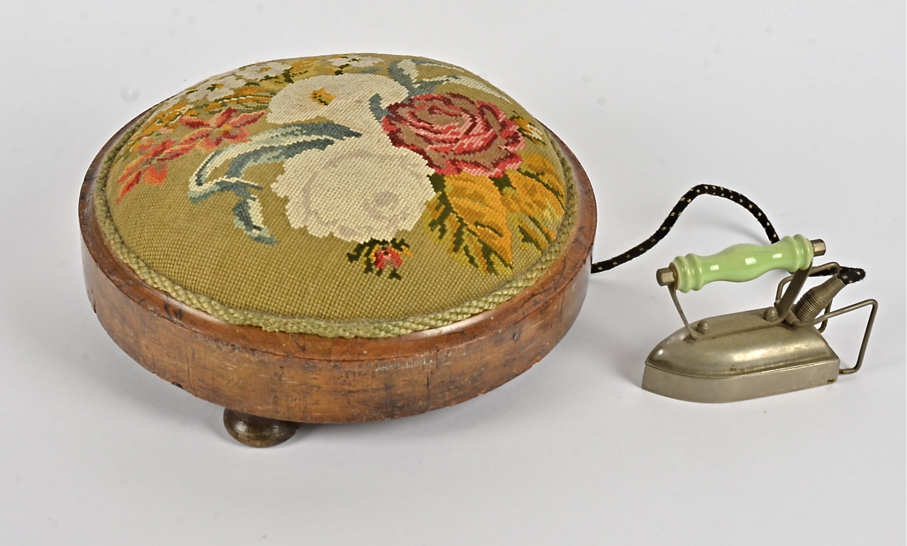 A 20th Century footstool, embroided with flowers upon a green ground, together with a 1950's