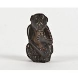 A Japanese boxwood netsuke of a monkey concealing a peach, with possible artist's mark to base,