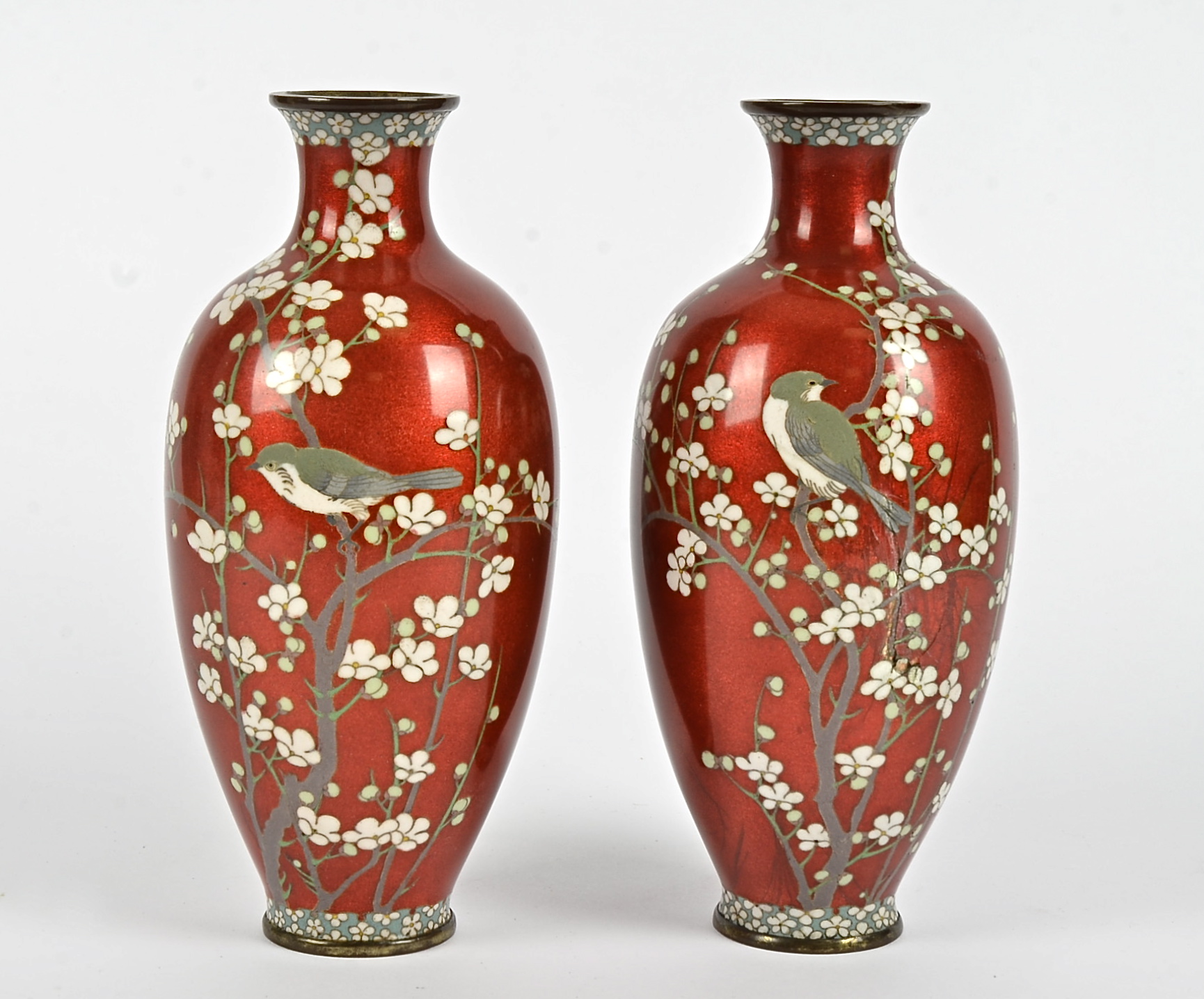 A pair of Japanese cloisonné vases, red ground decorated with birds on floral branches, height 24cm,