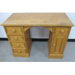 A contemporary pine knee hole desk, four short drawers to one side, one short and one covered to the