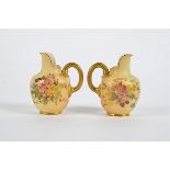 A pair of Royal Worcester blush ivory jugs, with handpainted floral decoration and gilt, height 10.