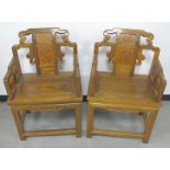 A pair of Chinese hardwood carved temple chairs, the wooden seats with carved back splat design,