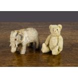 A Steiff miniature teddy bear, with light golden mohair, black glass eyes, remains of black