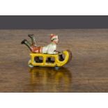 A Distler Penny Toys boy on sleigh, lithographed tinplate, boy lying down with legs in air and