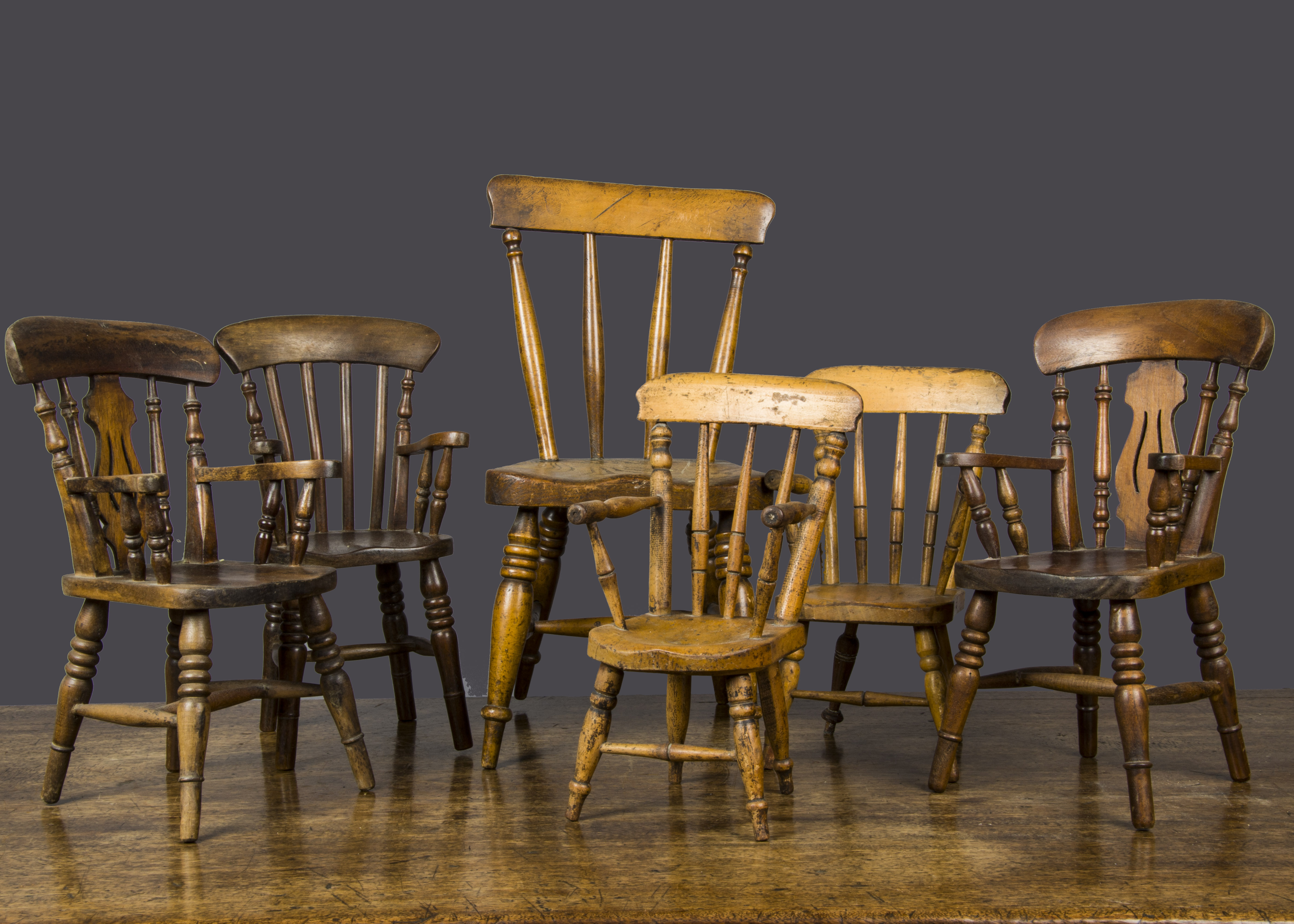 Six doll’s country kitchen chairs, a near-pair of late 19th Century varnished wooden chairs —10½