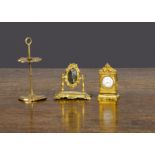 Gilt metal dolls’ house items, a dressing table mirror —2in. (5cm.) high (glass cracked), a mantel