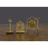 Gilt metal dolls’ house items, a bird cage with wax bird —2in. (5cm.) high; an umbrella stand with