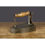An iron box iron, with turned wooden handle and slug —7in. (18cm.) long
