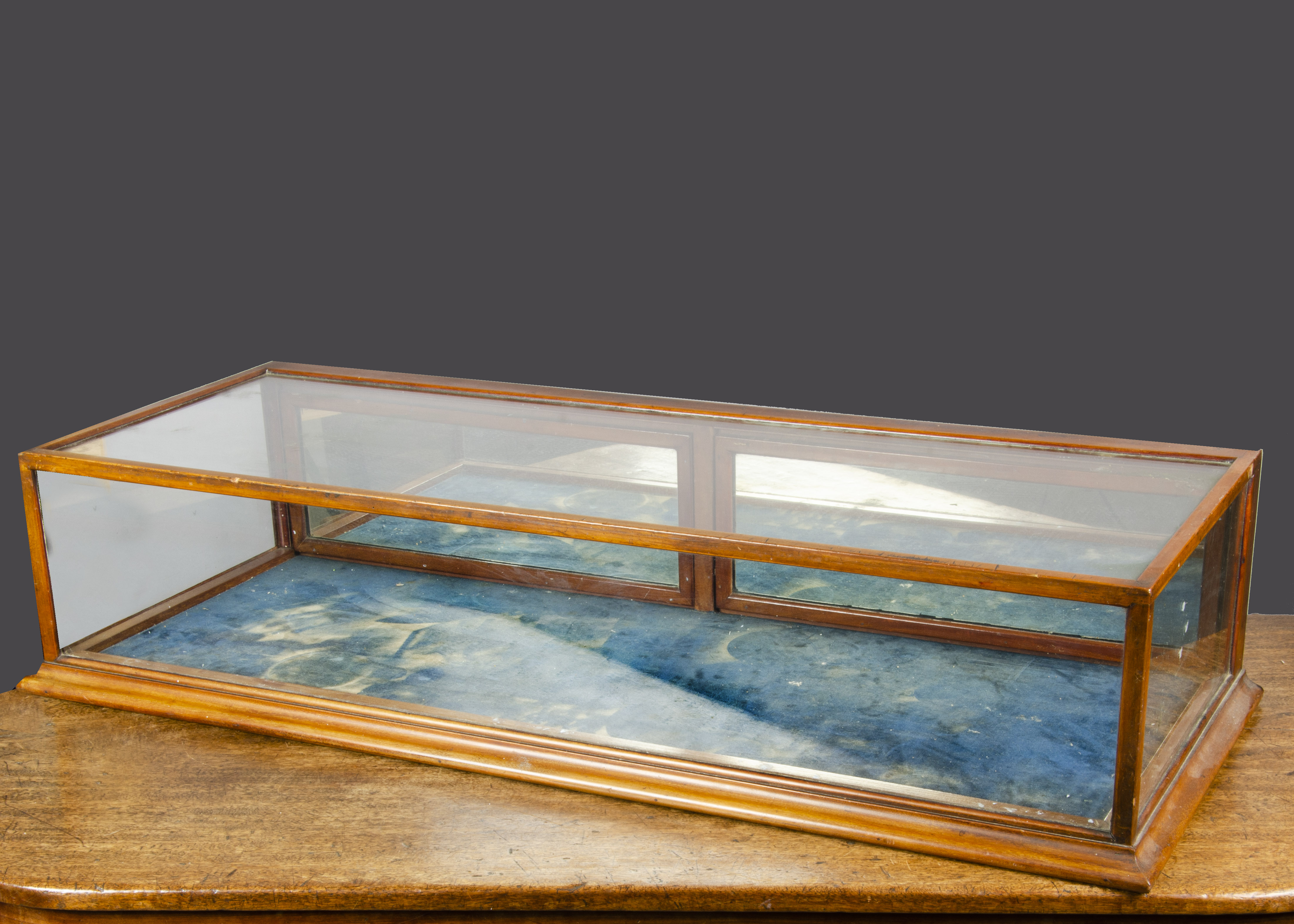 A late 19th Century retailer’s counter-top display cabinet, with mirrored back opening doors and