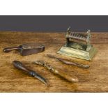 A Felton Murcott & Needham brass knife sharpener, each end with basket of flowers and royal crest on