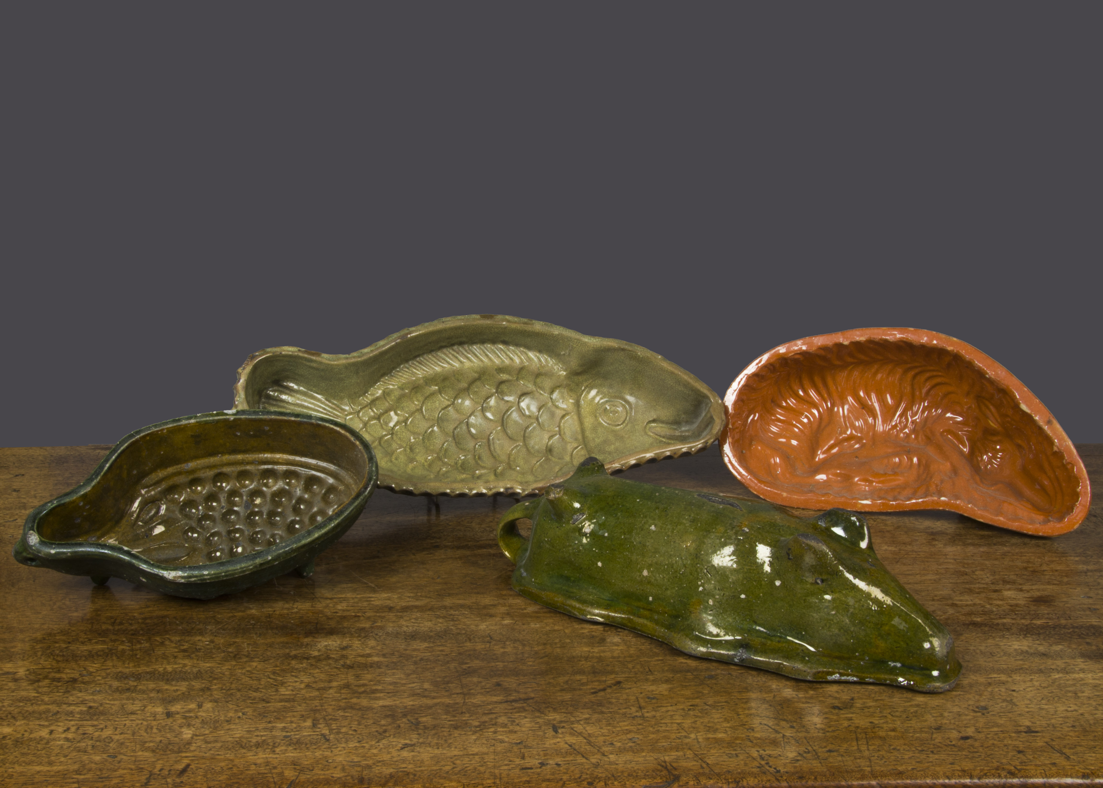 Four Continental pottery moulds, a fish with pale green glazed interior —17½in. (44.5cm.) long; a