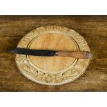 A carved wood ‘Our Daily Bread’ bread board, —12in. (30.5cm.) wide; and a George Wing bread knife