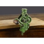 A late 19th Century cast-iron table top runner bean shredder, painted green with turned wooden
