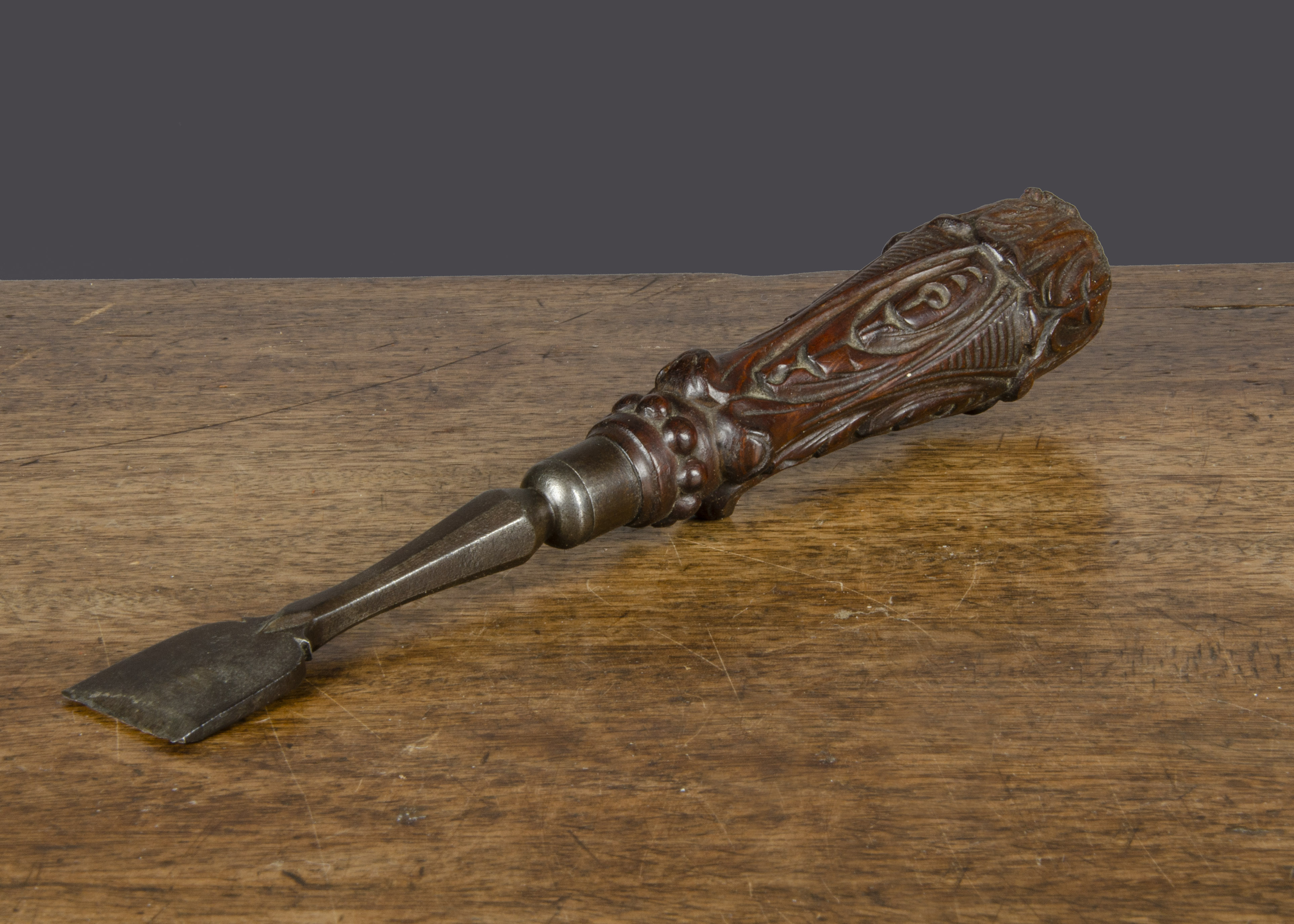 An ornate 19th Century button hole chisel, the hardwood handle carved with leaves and steel tool —