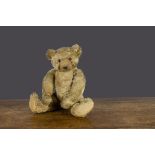 'Frowning Bear' a Farnell teddy bear 1920s, with blonde mohair, orange and black glass eyes,