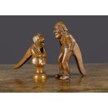 A French carved wooden elderly couple nutcrackers, the man a full figure with hands in his pockets