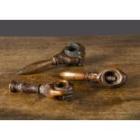 Three carved wooden fist nutcrackers, each holding a nut with srew-action ornate handle, one