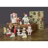 Bisque character cake decorations, a seated Mr Punch —1½in. (4cm.) high, a Punch and Judy booth with