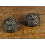 A pair of Japanese bronze fishing basket ink wells, with woven sides, the lids with assorted fish