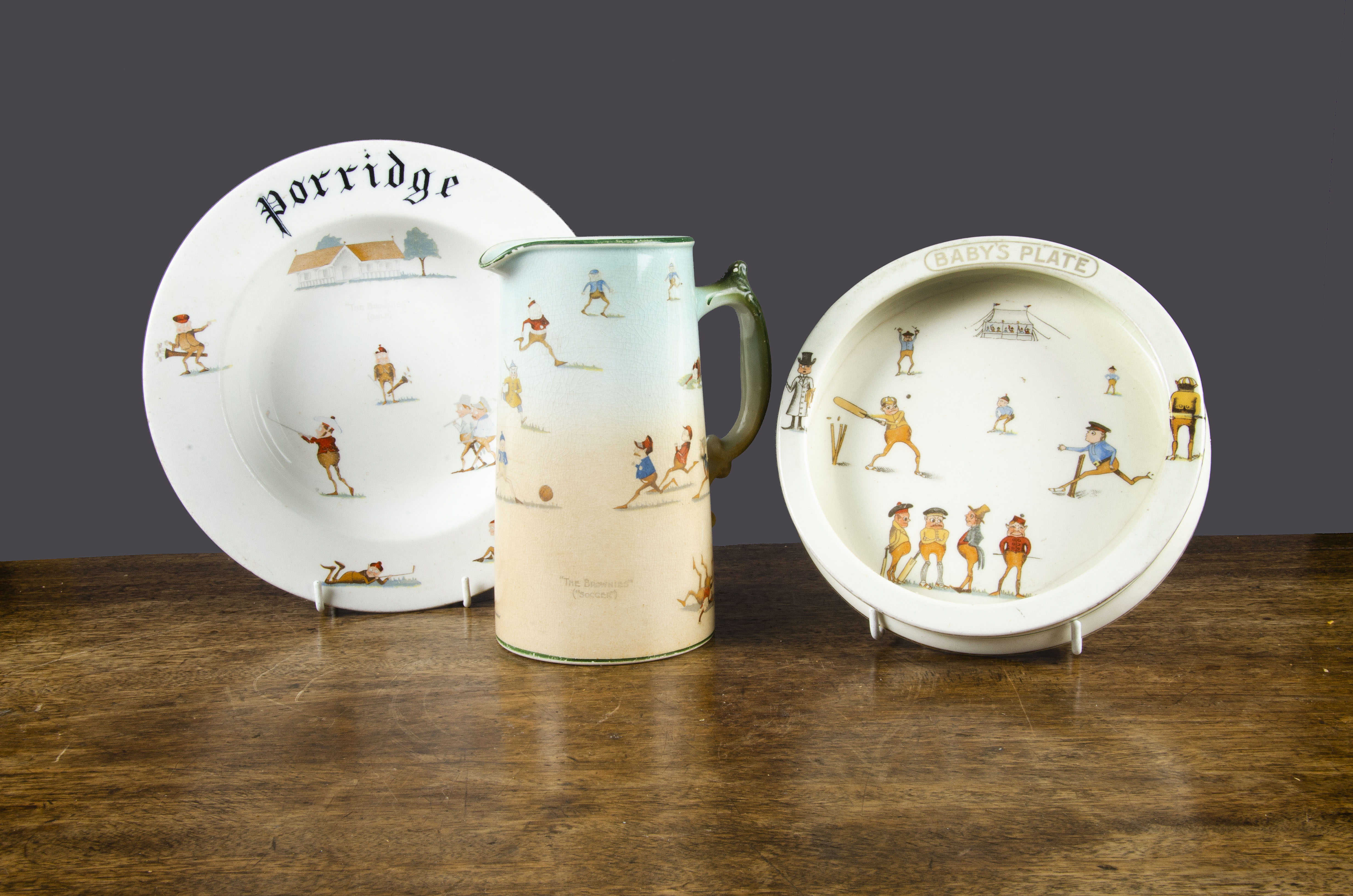 Three Brownie Sporting pieces, a ‘Porridge’ bowl; a jug and a ‘Baby’s Plate’