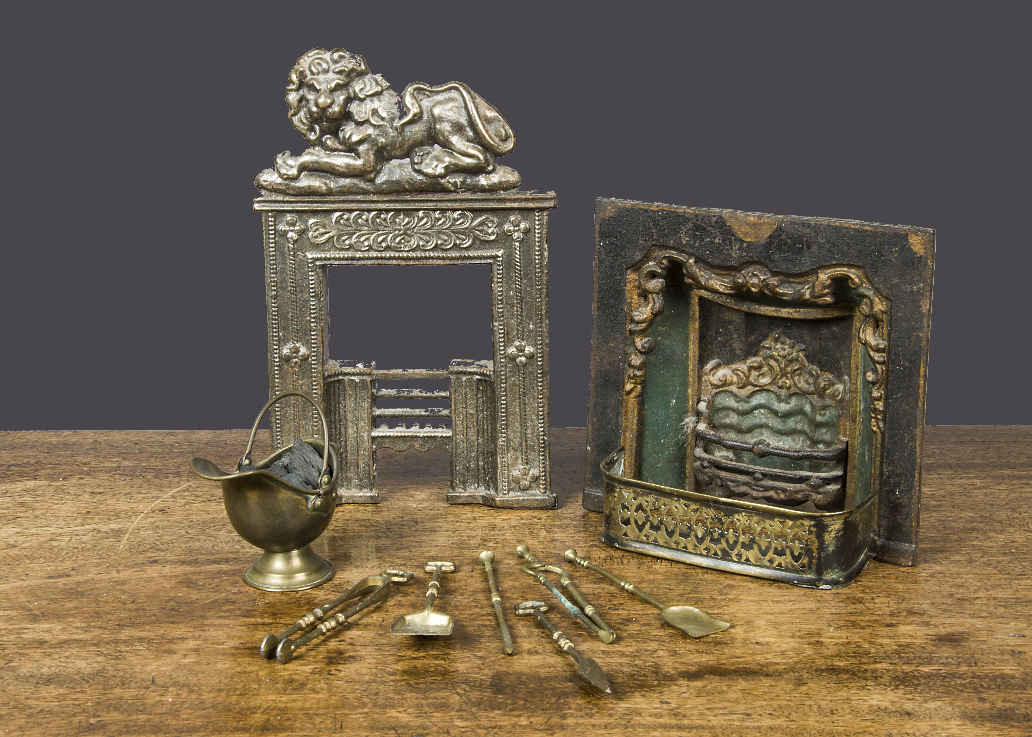 Two miniature or sample fire places, a polished cast-iron fire surround and grate surmounted with