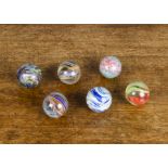 Six late 19th Century large hand-made marbles, three onions skins, one multicoloured —1½in. (4cm.)