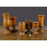 Six turned wood stemmed cups, mainly 19th Century, one with stained banding and another urn